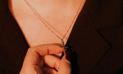 Wearing a cross necklace and holding in hand